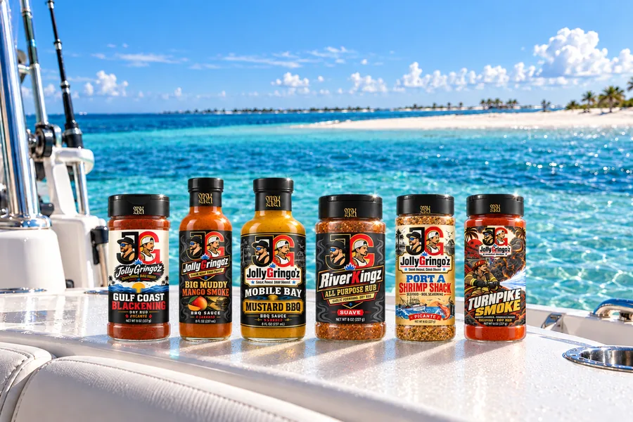 The six JollyGringo'z Starting Lineup bottles on a boat deck off a turquoise sandbar